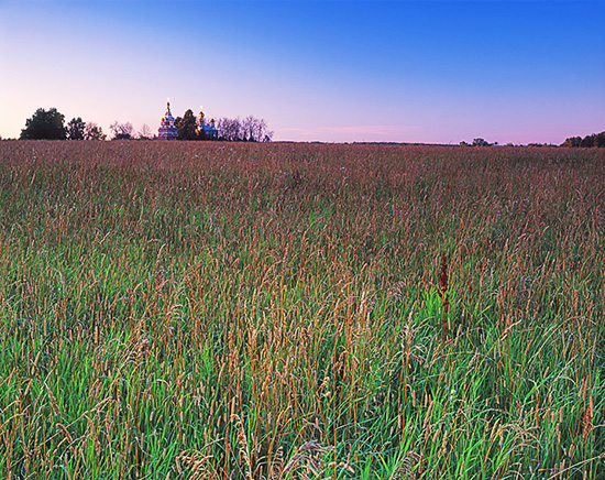 Классический пример расположения плоскости резкости в пейзаже: плоскость лежит на поверхности земли, поэтому трава на переднем плане не менее резкая нежели церковь на горизонте.